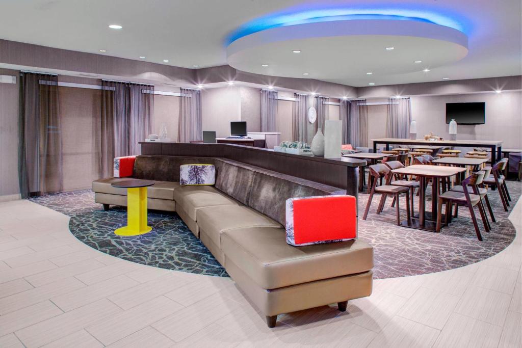 a lobby with a couch and tables and a restaurant at SpringHill Suites by Marriott Memphis East Galleria in Memphis