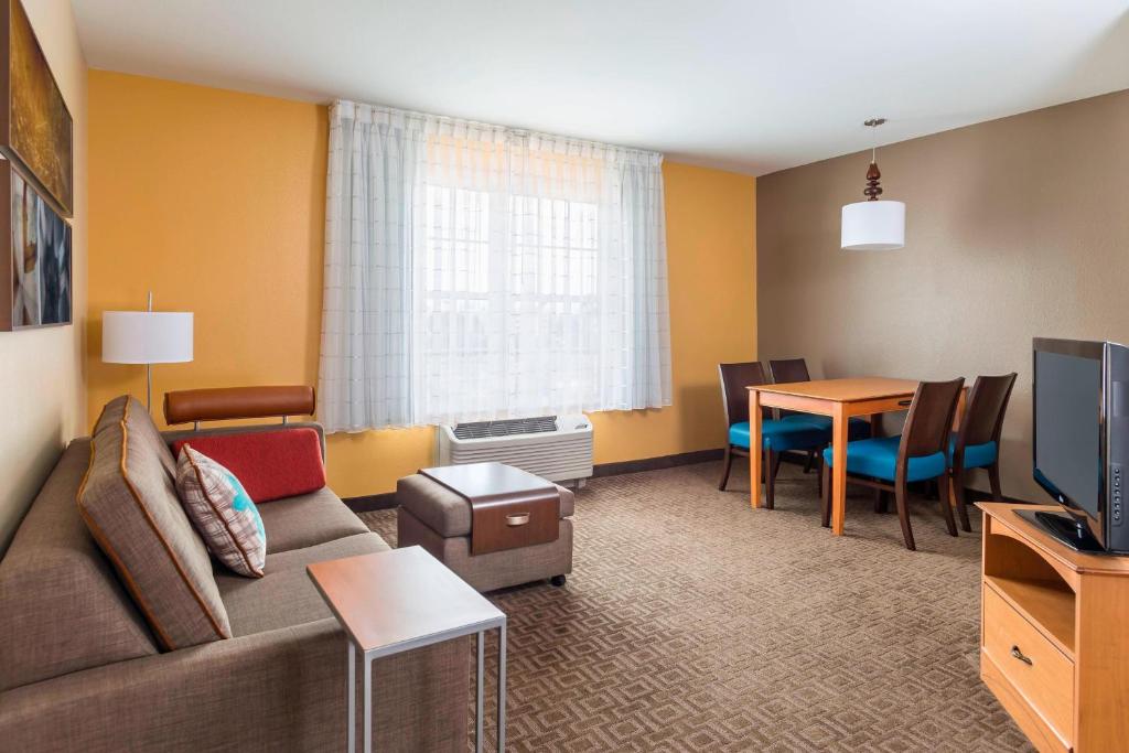 a living room with a couch and a dining room at TownePlace Suites Phoenix North in Phoenix