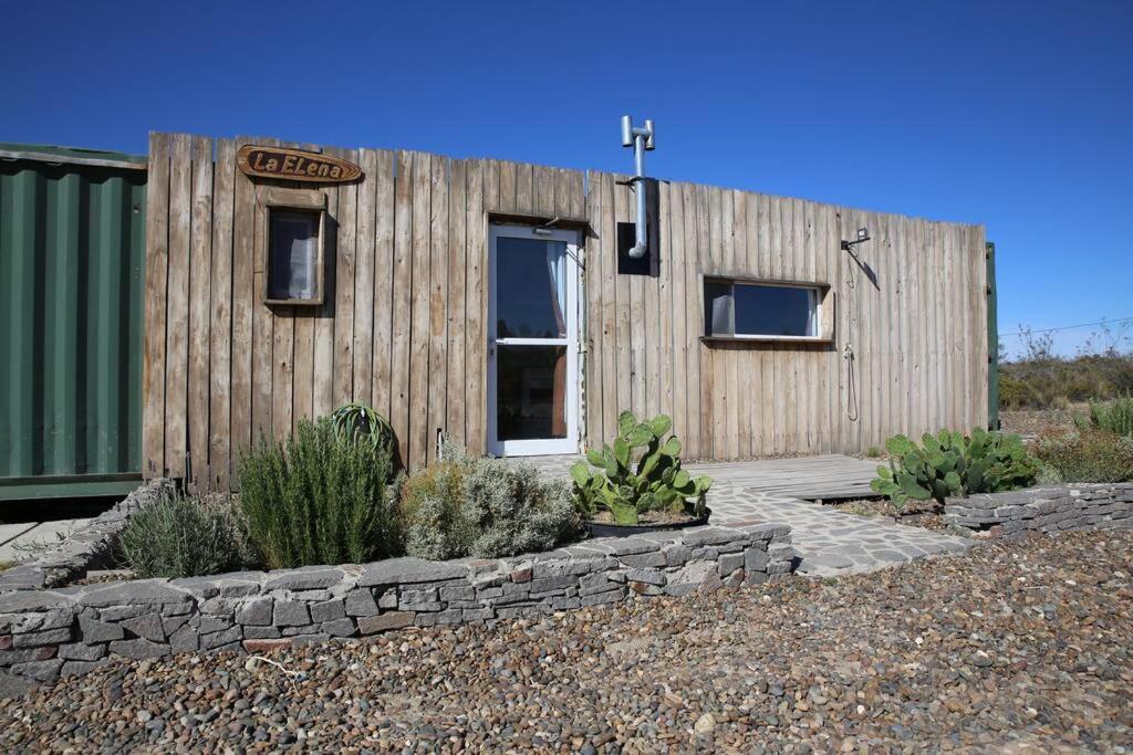 a small wooden building with a sign on it at Casa container a 15km de Madryn in Puerto Madryn