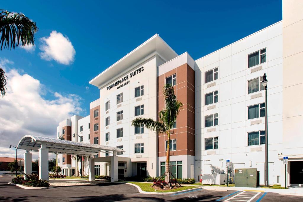 TownePlace Suites by Marriott Miami Homestead في هومستيد: مبنى مستشفى مع مظلة في موقف للسيارات