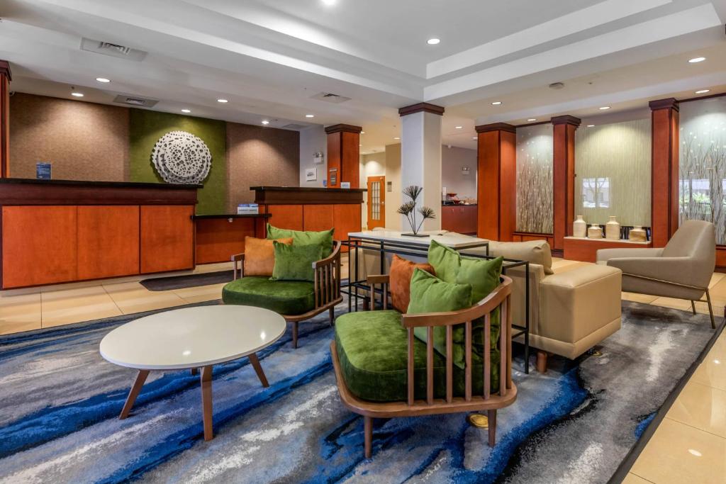 a lobby with chairs and a table and a counter at Fairfield Inn and Suites Holiday Tarpon Springs in Holiday