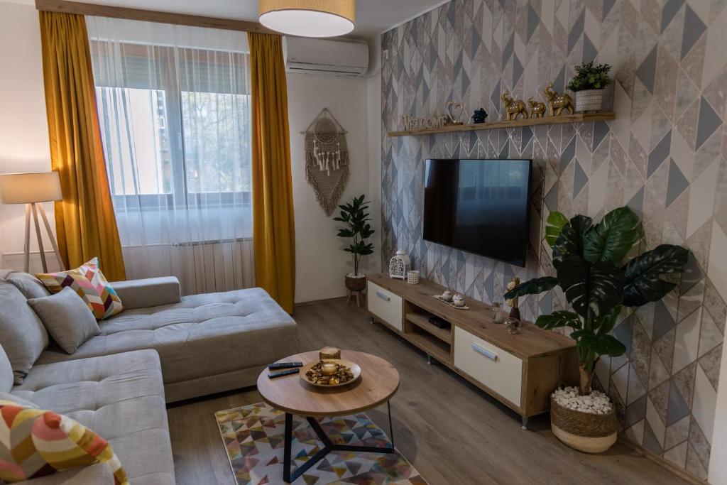 a living room with a couch and a tv at Apartman Mila23 in Rospi Ćuprija