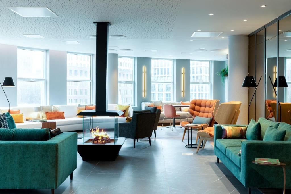ein Wohnzimmer mit Sofas und Stühlen sowie einem Kamin in der Unterkunft Residence Inn by Marriott The Hague in Den Haag