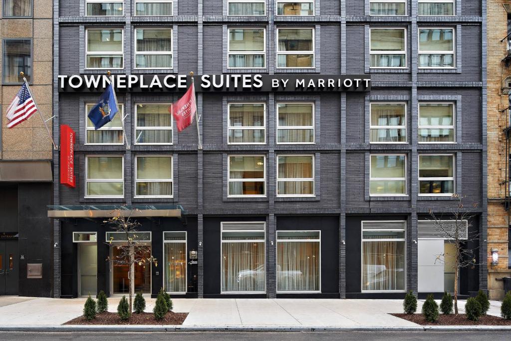 um edifício com duas bandeiras à frente em TownePlace Suites by Marriott New York Manhattan/Times Square em Nova Iorque