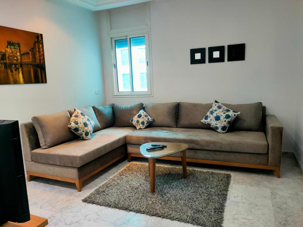 sala de estar con sofá y mesa en FLAT JINEN DU LAC 2, en Túnez