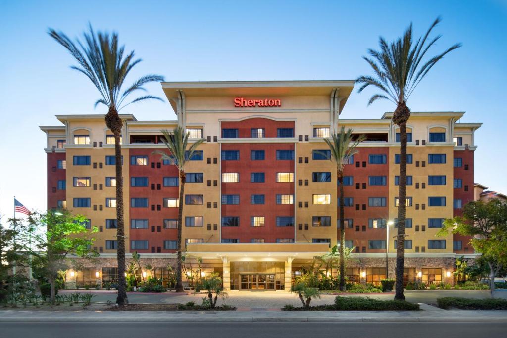 a large hotel with palm trees in front of it at Sheraton Garden Grove-Anaheim South in Anaheim