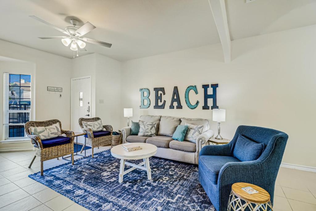 een woonkamer met een bank, stoelen en een tafel bij Feelin' Beachy in Padre Island