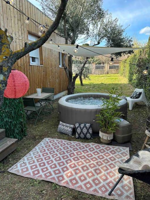 a backyard with a hot tub and an umbrella at Studio provençal atypique avec jacuzzi privé in Sanary-sur-Mer