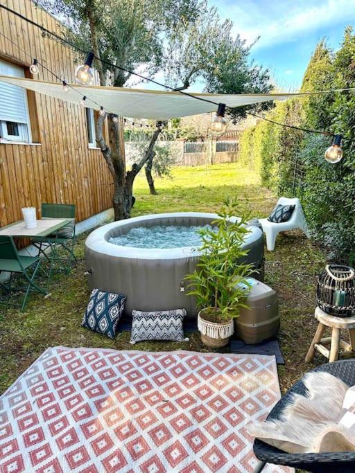 a patio with a hot tub in a yard at Studio provençal atypique avec jacuzzi privé in Sanary-sur-Mer