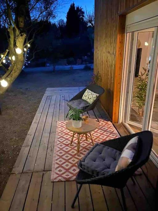 a chair and a table on a wooden deck at Studio provençal atypique avec jacuzzi privé in Sanary-sur-Mer