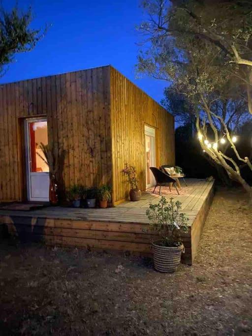 a small wooden house with a deck and a table at Studio provençal atypique avec jacuzzi privé in Sanary-sur-Mer