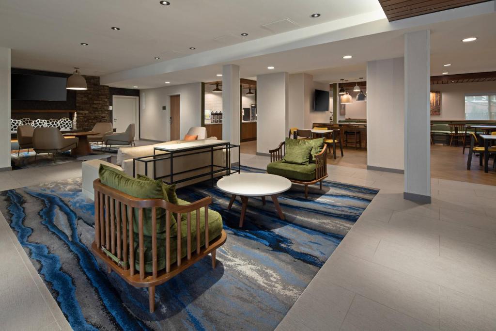 a lobby with chairs and tables on a rug at Fairfield by Marriott Inn & Suites Seattle Sea-Tac Airport in SeaTac