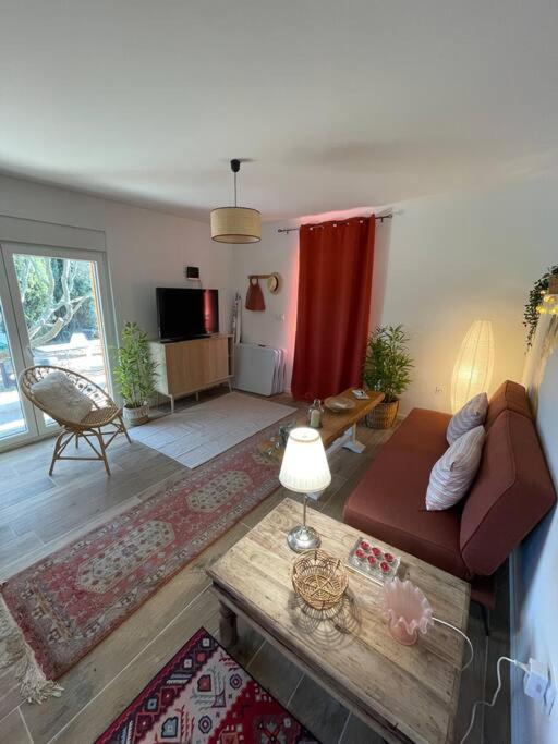 a living room with a couch and a table at Studio provençal atypique avec jacuzzi privé in Sanary-sur-Mer