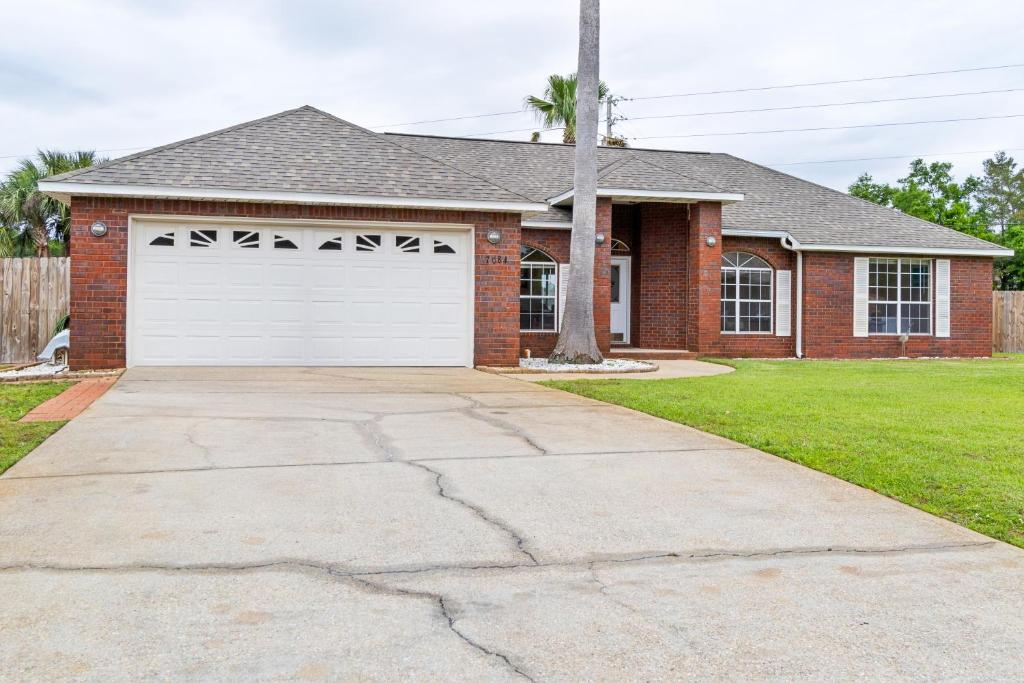 a red brick house with a white garage at East Bay Getaway in Navarre