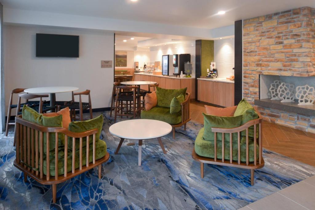 a lobby with chairs and tables and a fireplace at Fairfield Inn & Suites by Marriott Pittsburgh New Stanton in New Stanton