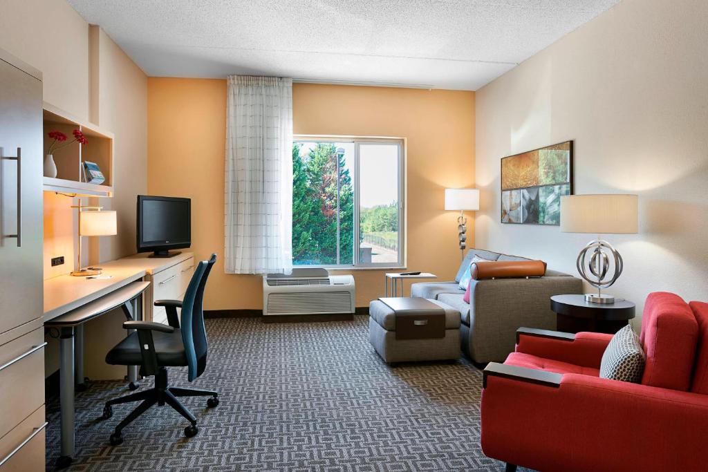 Habitación de hotel con escritorio y sala de estar. en TownePlace Suites by Marriott Rock Hill en Rock Hill