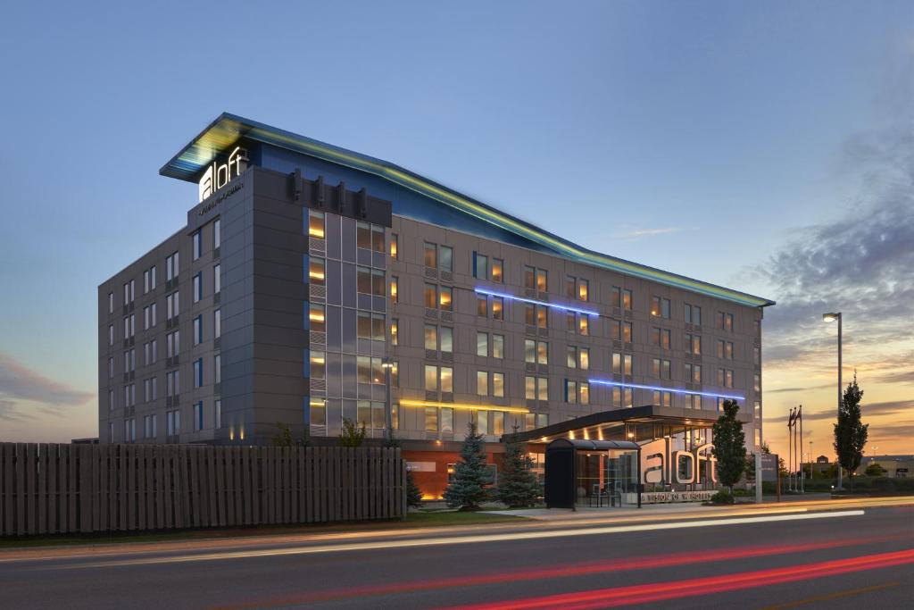 a large building with a lit up building at Aloft Vaughan Mills in Vaughan