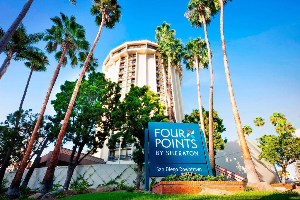 a sign in front of a building with palm trees at Four Points by Sheraton San Diego Downtown Little Italy in San Diego