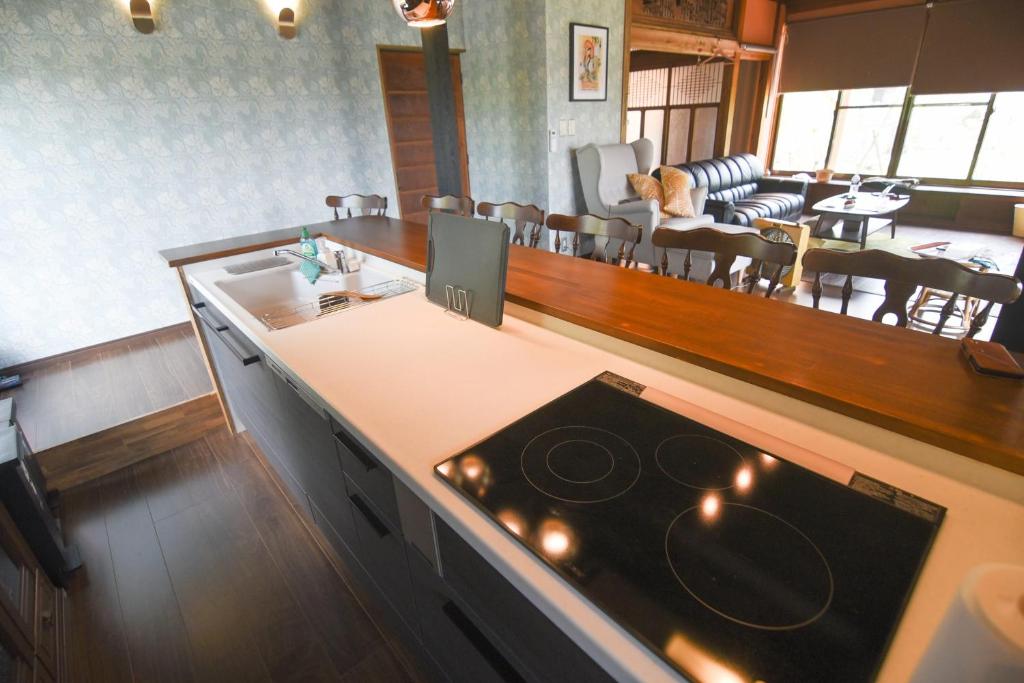 a kitchen with a stove top oven next to a living room at 山鹿師蔵 in Yamaga