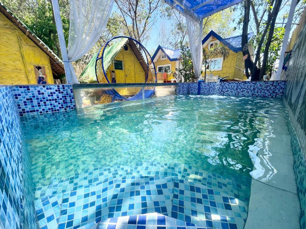 Lingayen的住宿－Beachfront Glamping with Mini Pool Exclusive Property，水面上蓝色瓷砖的游泳池