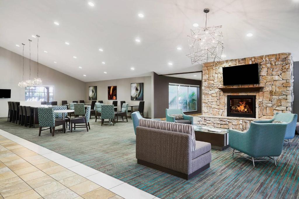 a lobby with a fireplace and chairs and a waiting room at Residence Inn Temple in Temple