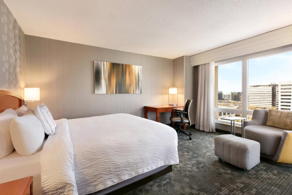 a hotel room with a bed and a desk and a window at Courtyard by Marriott Tysons McLean in Tysons Corner