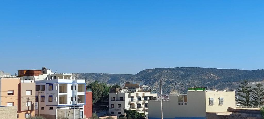 a group of buildings with mountains in the background at Tamraght agadir in Tamraght Ouzdar