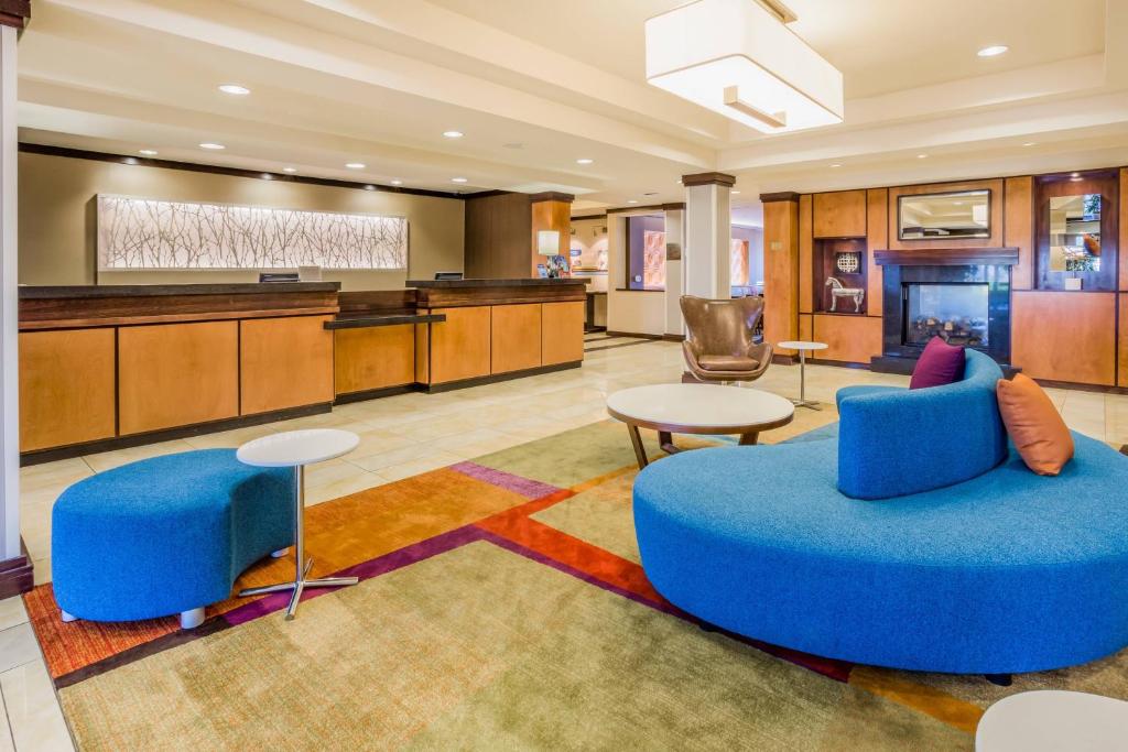 a hotel lobby with a blue couch and tables at Fairfield Inn and Suites Turlock in Turlock