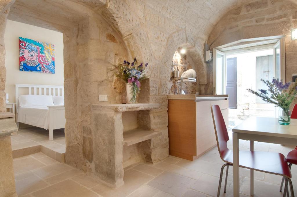 eine Küche und ein Esszimmer mit einer Steinmauer in der Unterkunft Vico Sant'Antonio in Carpignano Salentino