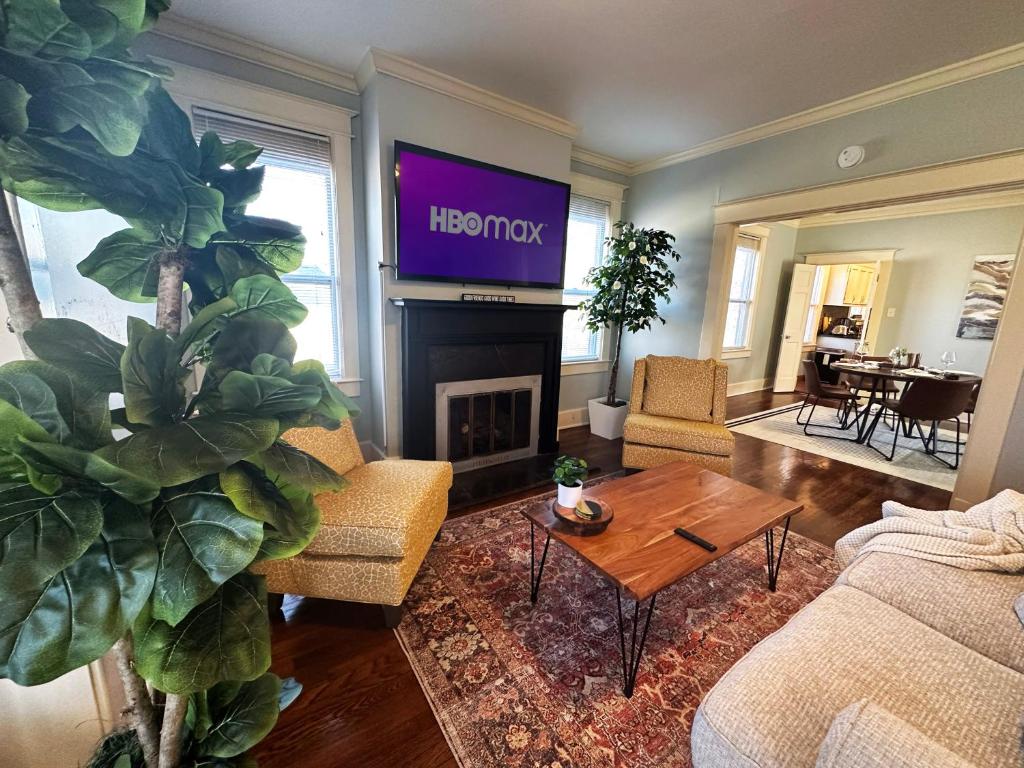 a living room with a television above a fireplace at Luxury Lenox Townhouse in Memphis