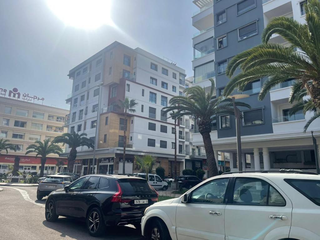 two cars parked on a street in front of buildings at Résidence EL MEDKOURI in Mohammedia