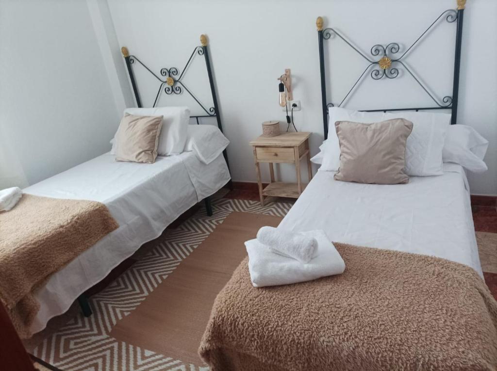 a room with two beds and a table with a bedphasis at CASA SENDERO DEL RIO in El Bosque