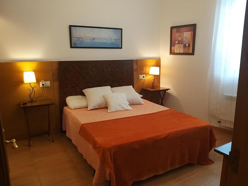 um quarto com uma cama com duas almofadas em Apartamento con pequeño jardín en el centro em Ferrol