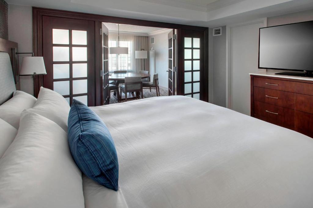 a bedroom with a large white bed with a blue pillow at Marriott Philadelphia West in West Conshohocken