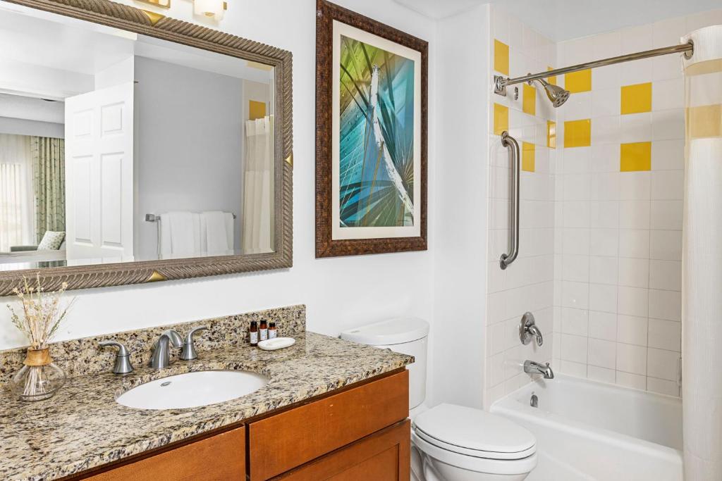 a bathroom with a sink and a toilet and a mirror at Marriott&#39;s Legends Edge at Bay Point in Panama City Beach