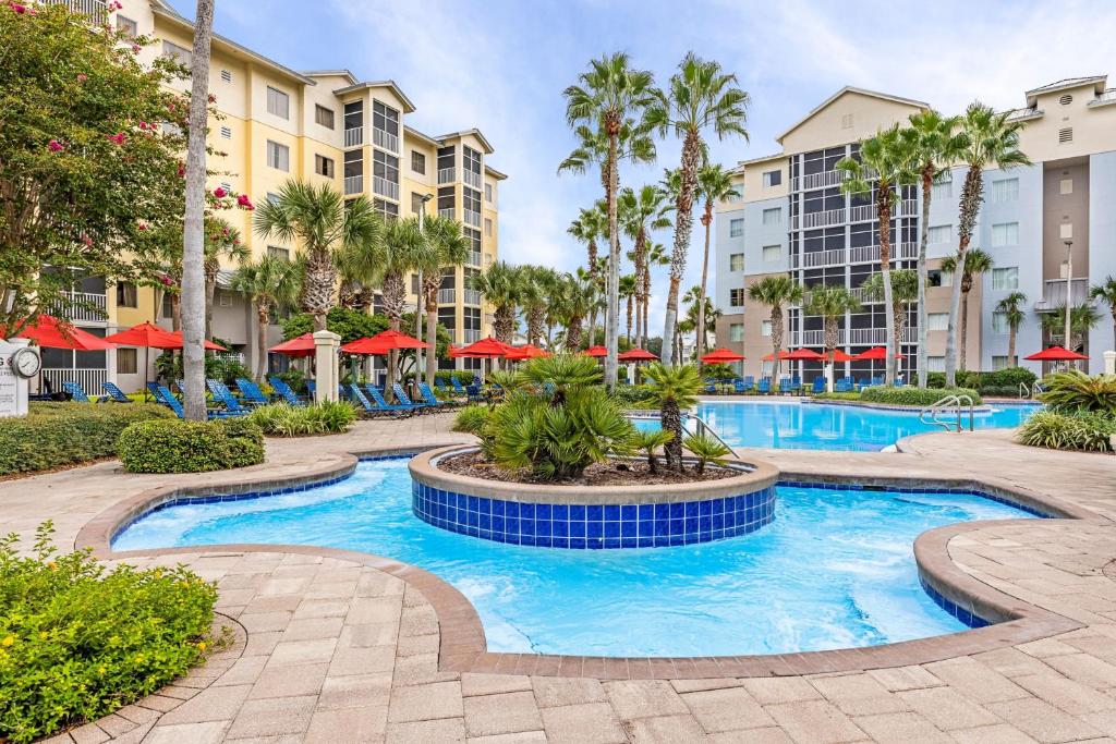 a pool at a resort with palm trees and buildings at Marriott&#39;s Legends Edge at Bay Point in Panama City Beach