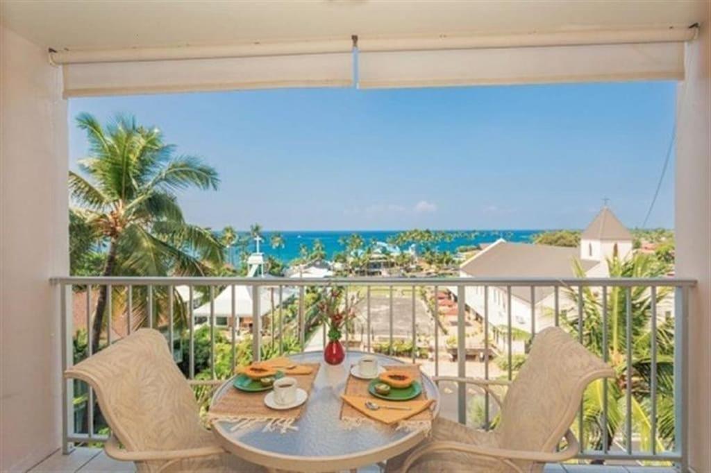 - une table sur un balcon avec vue sur l'océan dans l'établissement Full Ocean Sunset View, Fully Equipped 6th Floor Condo KV602, à Kailua-Kona