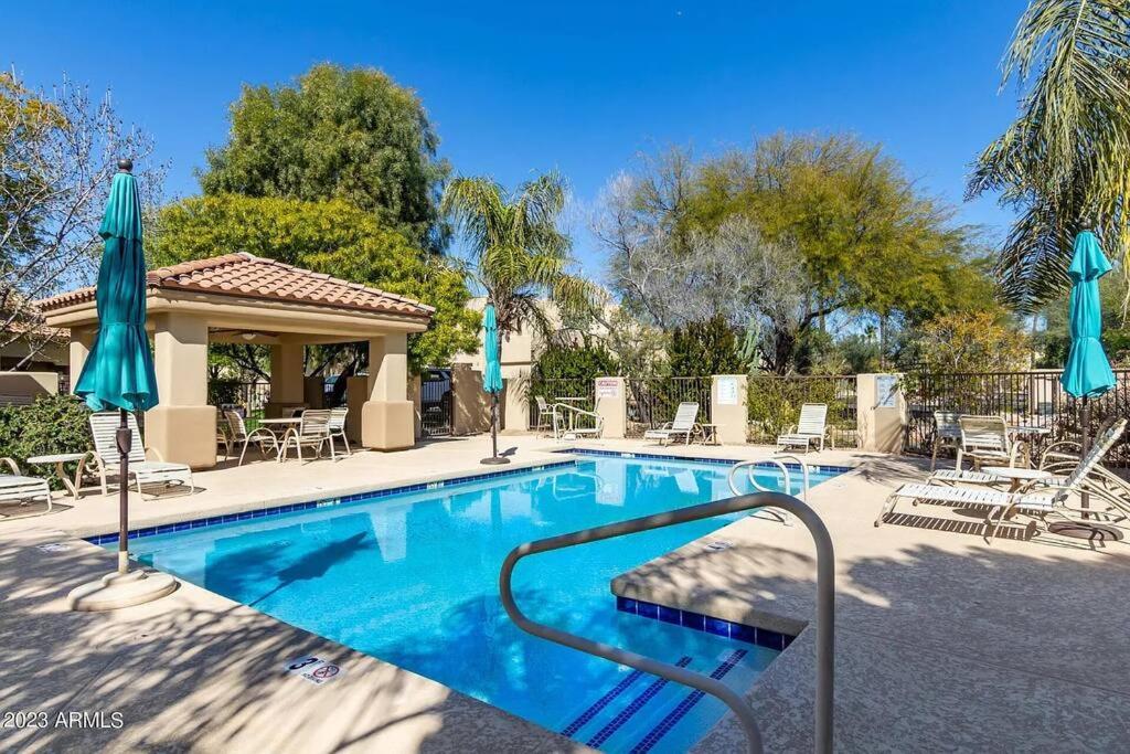 a swimming pool with chairs and umbrellas at Location, Leisure, & Luxury in Scottsdale