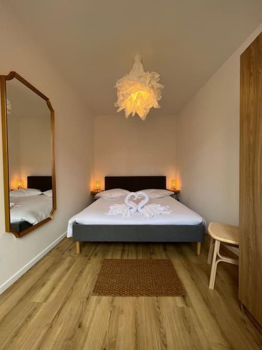 - une chambre avec un lit et un grand miroir dans l'établissement Bob - SuperConfort - HyperCentre, à Mulhouse