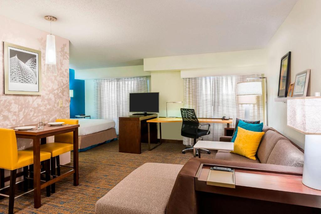 a hotel room with a bed and a living room at Residence Inn Macon in Macon