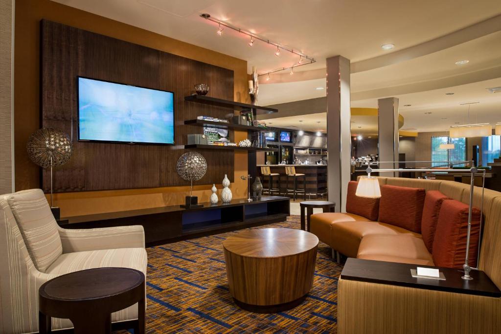 a hotel lobby with a couch and a tv at Courtyard by Marriott Hanover Lebanon in Lebanon