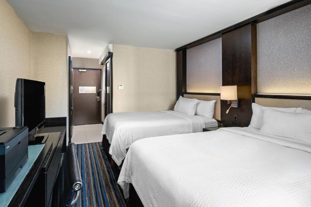 a hotel room with two beds and a flat screen tv at Courtyard New York Manhattan/Times Square in New York