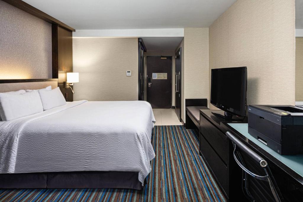 a hotel room with a bed and a flat screen tv at Courtyard New York Manhattan/Times Square in New York