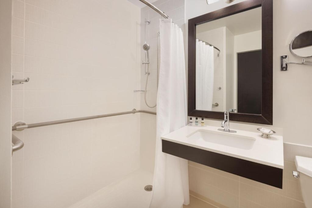 a bathroom with a sink and a shower and a mirror at Courtyard New York Manhattan/Times Square in New York