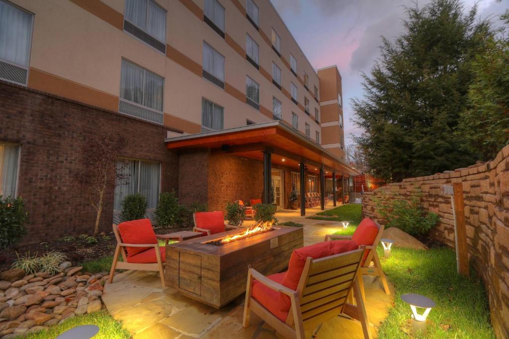 un patio avec des chaises et un foyer extérieur en face d'un bâtiment dans l'établissement Fairfield Inn & Suites by Marriott Gatlinburg Downtown, à Gatlinburg