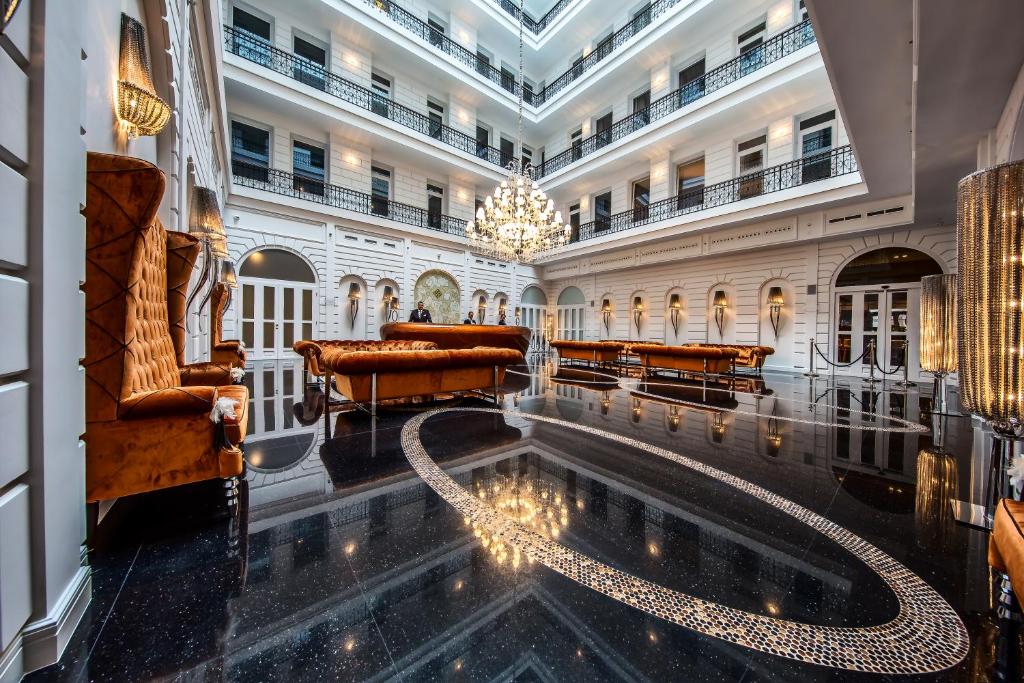 a lobby with a pool in the middle of a building at Prestige Hotel Budapest in Budapest