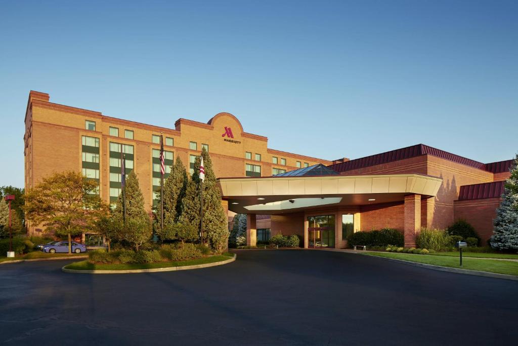 a building with a parking lot in front of it at Marriott Hartford/Windsor Airport in Windsor