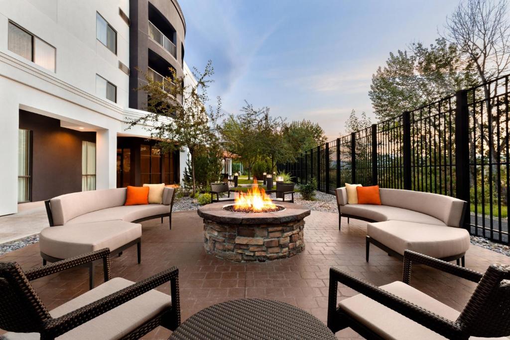 a patio with couches and a fire pit with a fire pit at Courtyard Missoula in Missoula