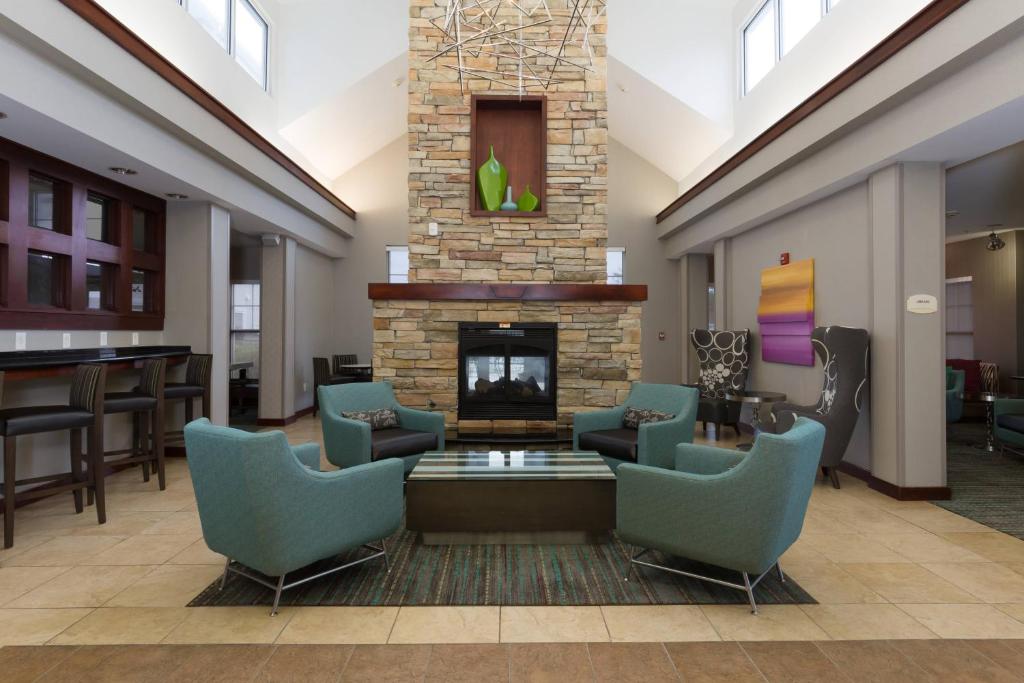 a lobby with a fireplace and chairs and a table at Residence Inn by Marriott Baton Rouge near LSU in Baton Rouge