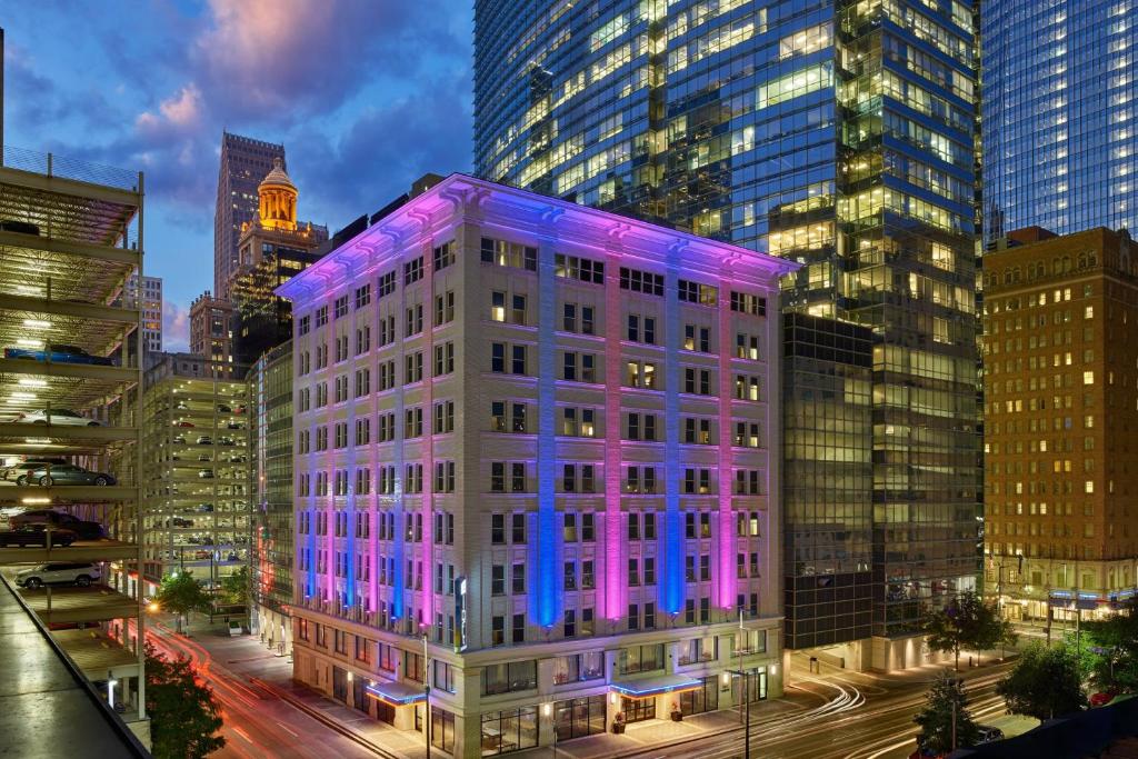 a building with purple lights on it in a city at Aloft Houston Downtown in Houston